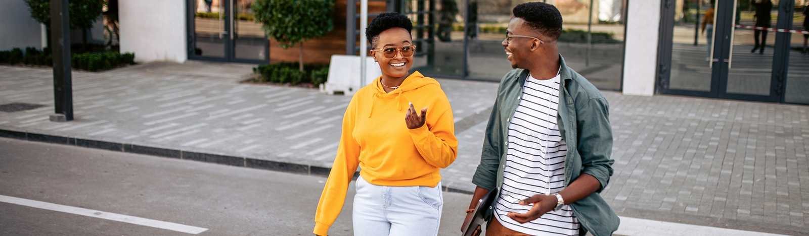 Two young adults crossing the street